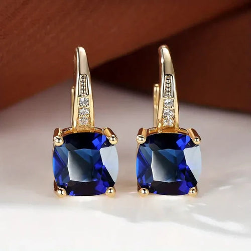 Goldfarbene Ohrhänger mit blauem Schmuckstein
