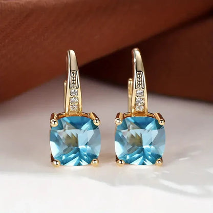 Goldfarbene Ohrhänger mit blauem Schmuckstein